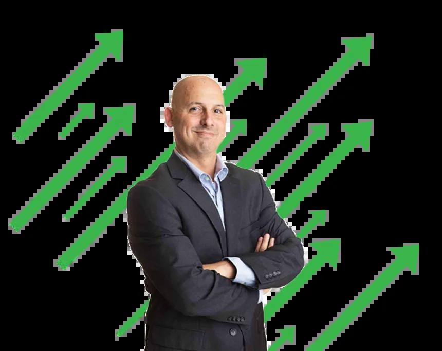 Analyst Kenny Glick stands arms crossed in front of green arrows pointing to upper right